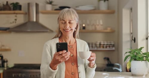 Senior Woman Using Smartphone at Home with Coffee