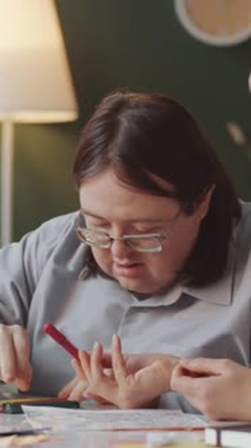 Young Adults Coloring Together Indoors with Colored Pencils