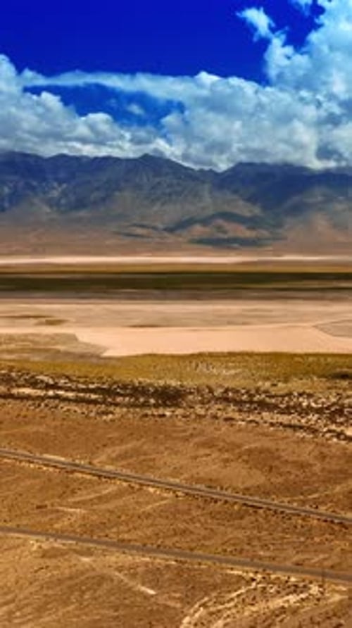Empty highways crossing the hot desert. Arid landscape of Death Valley from aerial perspective.