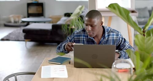 Man Working on Laptop at Home with Coffee