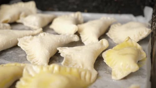 24, Raw pies are poured with liquid egg before baking. Cooking pies.