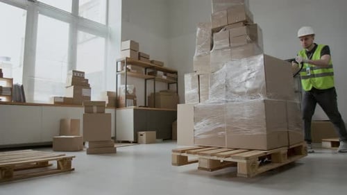 Man Moving Pallet of Boxes with Pallet Jack