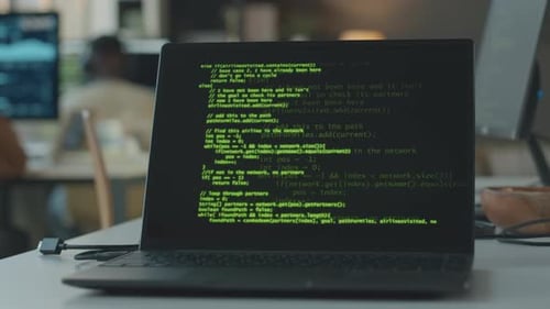 Green Computer Code on Laptop Screen in Office