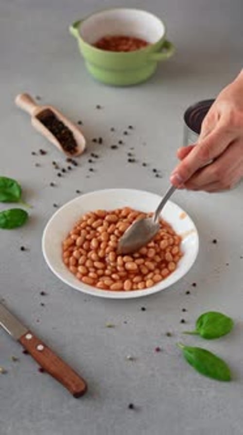 Baked Beans in tomato sauce in a plate against a grey background. Vertical video