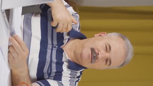 Vertical video of Home office worker sprays perfume on old man.