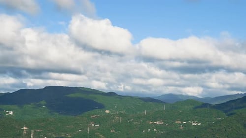Weiße Wolken zogen schnell über die Berggipfel und Hochspannungstürme.