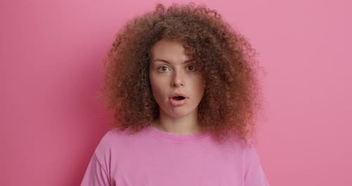 Woman smiling with positive expression against pink background