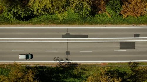 Auto, das auf einer Asphaltstraße fährt, von oben nach unten, Ansicht eines Fahrzeugs, das sich entlang der asphaltierten Autobahn bewegt, Luftaufnahme