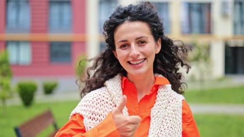 Cheerful Woman Gives Thumbs Up Outdoors