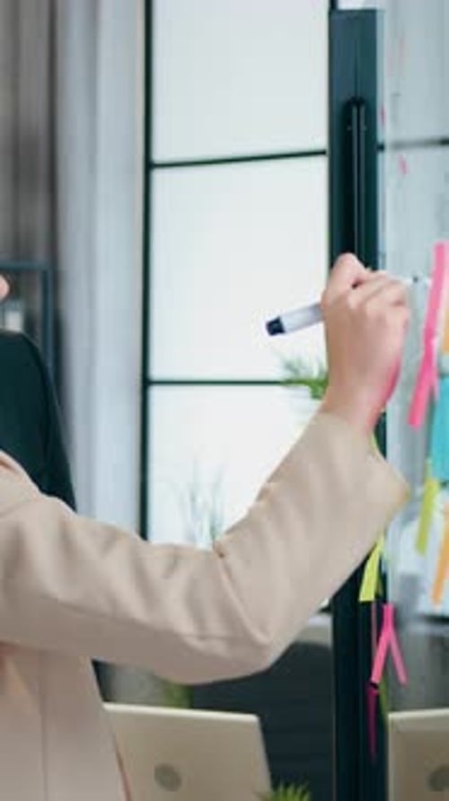 Side View of Woman and Her Creative Bearded Colleague Which Standing Near Glass Wall in Office Room