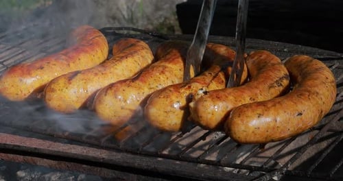 Delicious juicy sausages, cooked on the grill with a fire.