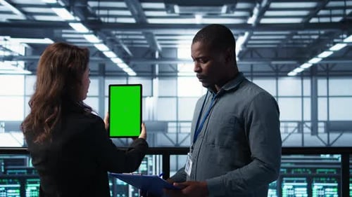 Technicians in Data Center Using Green Screen Tablet Reviewing Hardware