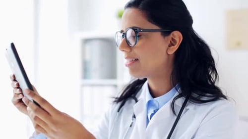 Doctor Uses Tablet Computer in Bright Office