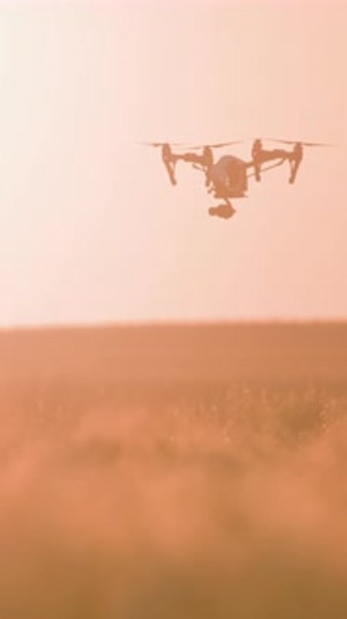 Sunset Scene with Drone Silhouette and Hazy Background Creating Cinematic Atmosphere with Warm