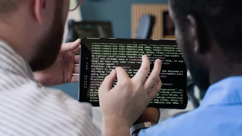 Junge Männer arbeiten im Büro an Code