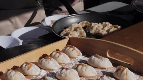 Dumplings being cooked and put on plates
