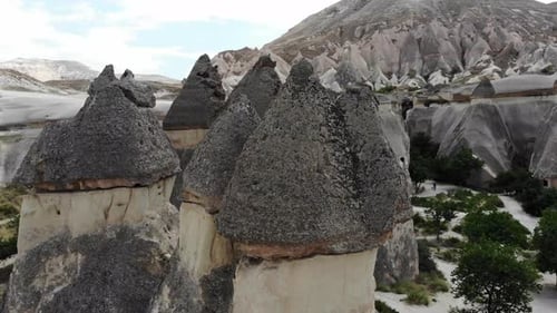 Un Zumbido Mavic Air comienza a elevarse en medio de chimeneas de hadas y pasa cerca de la parte superior de ellas antes