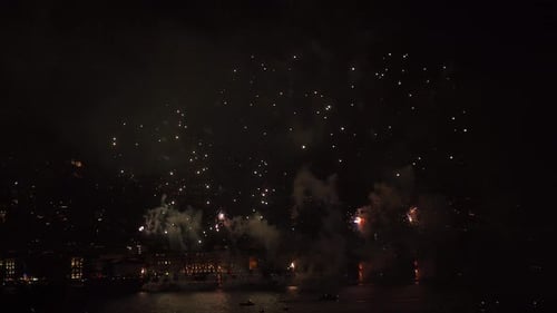 Bright Fireworks Explode over a City Skyline at Night