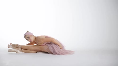 Ballerina Stretching in Pink Leotard in Studio