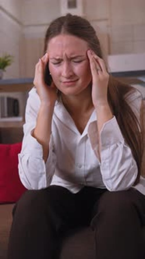 Young businesswoman suffering from headache at home