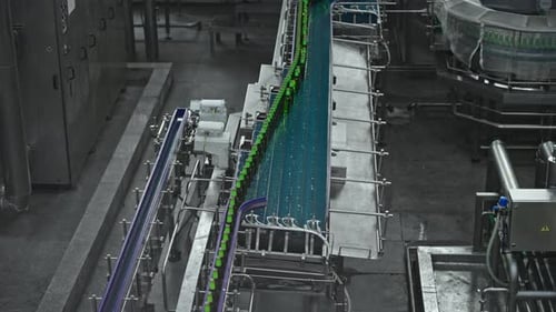 A Hightech Bottling Plant with an Automated Conveyor System Transports Green Glass Bottles Through
