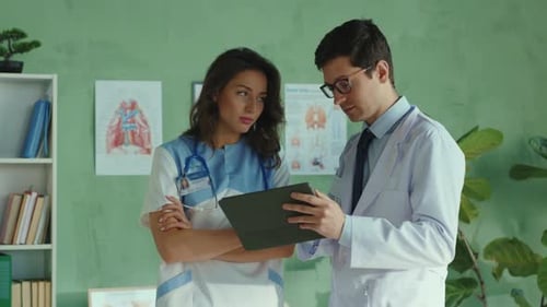 Doctors consulting digital tablet in hospital