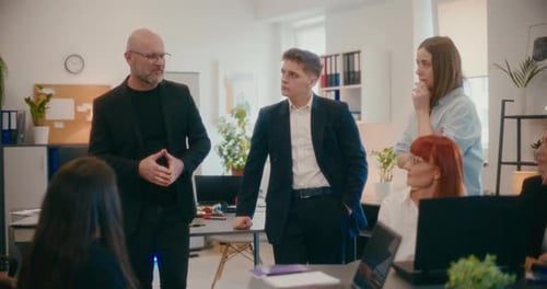 Manager Discussing with Colleagues in Meeting at Office