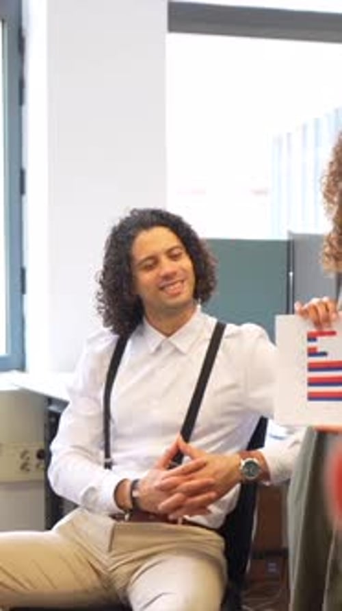 Young Colleagues Discussing a Bar Graph in Office