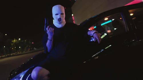 Young Man in White Balaclava Posing with Handgun