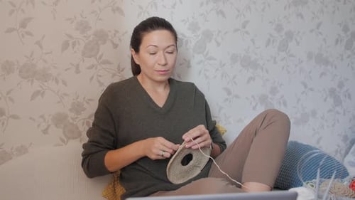 Woman Crocheting Project on a Sofa at Home
