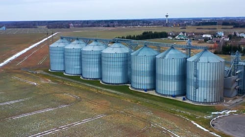 Getreidesilos aus Stahl für die Lagerung von Getreide auf dem Bauernhof mit modernem Getreideaufzug. Flugbahn