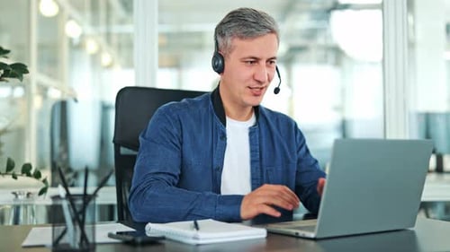 Professional Man Communicating Online with Headset in Office