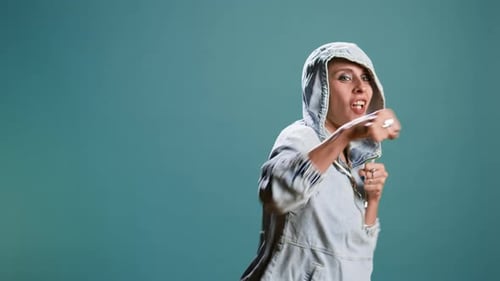 Strong Bold Woman Flexing Muscles and Throwing Punches in Studio