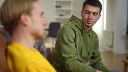 Two Young Adults in Conversation on Couch