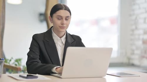Woman Works on Laptop in Bright Office