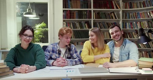 Portrait Shot of Young Caucasian Cheerful Group of Males and Females Students Sitting at Table in