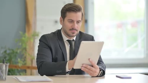Cheerful Businessman using Tablet PC