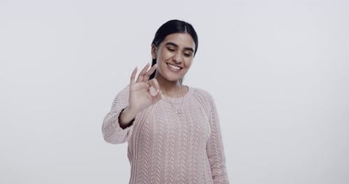 Happy, ok sign and face of woman in studio isolated on a white background