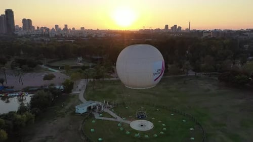 Aerial Shot Of Hot Air Balloon Descending Over Yarkon Park Against Sky In City