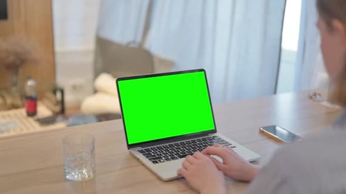 Young Woman Using Laptop with Green Screen