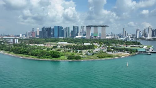 Singapore drone orbit shot over the Marina Bay, with Marina Barrage in shot, ocean water different c