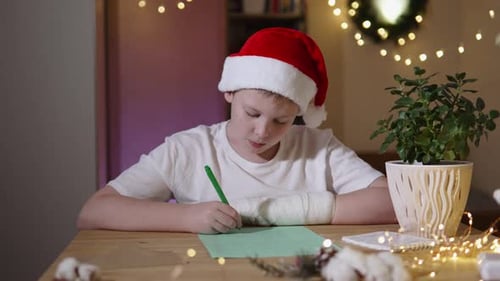 Young Boy in Santa Hat Writing Letter