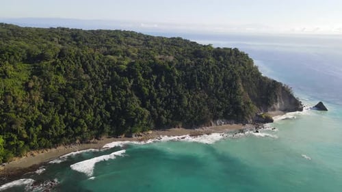 Slow aerial view of the side of an ocean cliff in Osa Peninsula, Costa Rica