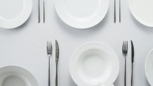 Arranging Elegant White Plates in Formal Place Setting