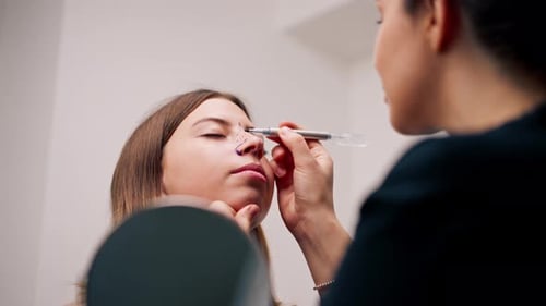 close-up plastic surgeon makes marks on a patient's face during a consultation before nose operation