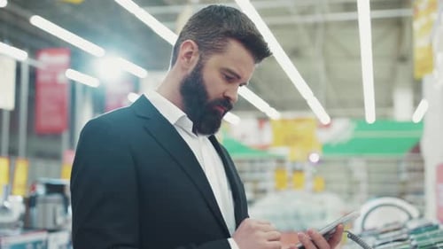 Young Beard Man Use Hold Touch Tablet Computer Talk with Seller Consultant in Tech Store Business
