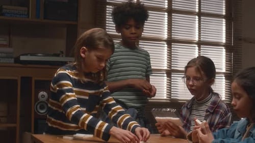 Multiethnic Kids Putting Tiles on Table During Game of Dominoes