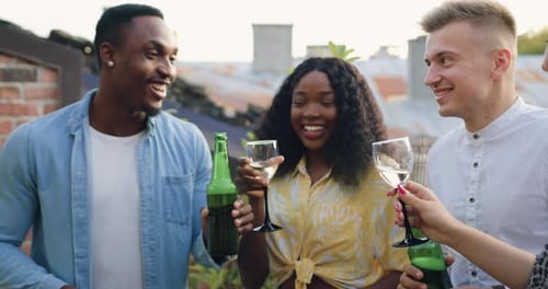 Attractive people which having fun together during friends party with beer and wine on the terrace