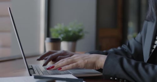 Woman Typing on Laptop at a Desk