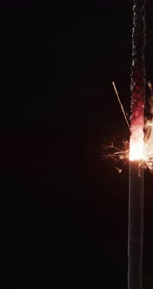 Sparkling Sparkler Burning Against Black Background